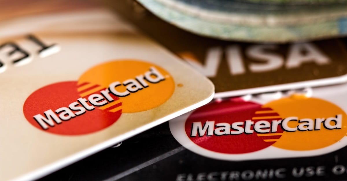 Cartões Mastercard e Visa empilhados, destacando o logotipo da Mastercard em foco