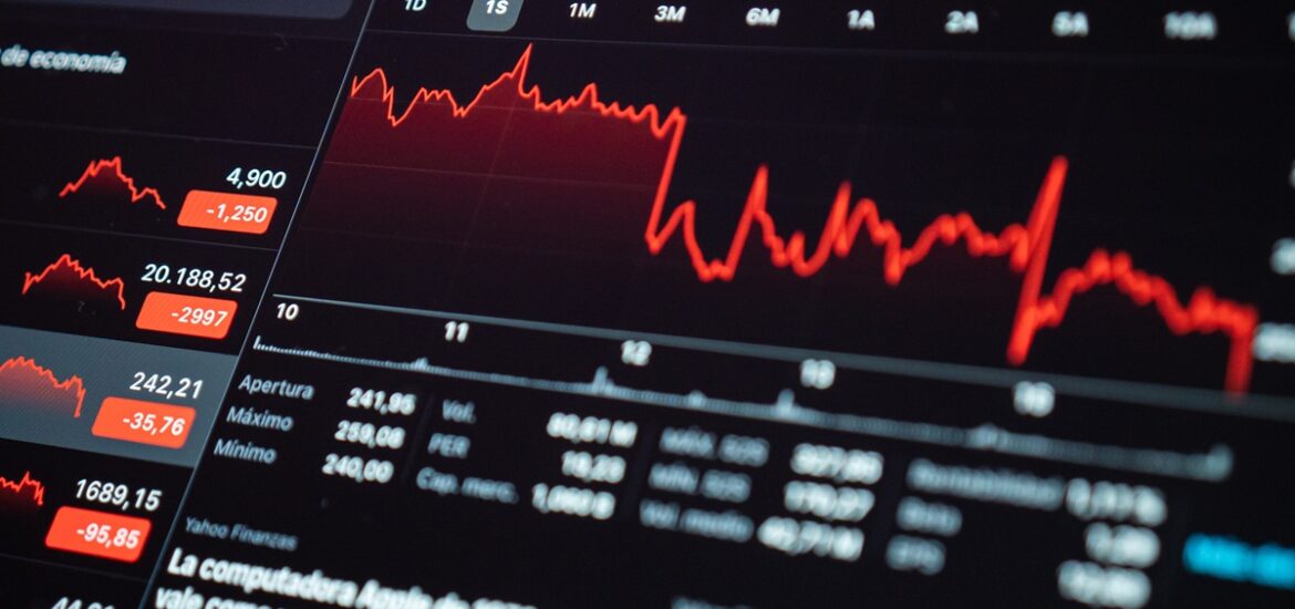 Gráfico financeiro em tela de computador mostrando linhas vermelhas em queda, refletindo oscilações no mercado devido ao aumento da taxa Selic.