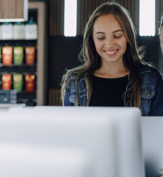 Duas mulheres sorridentes observando produtos em um ambiente comercial moderno, representando o impacto positivo do crescimento das microempresas no Brasil.